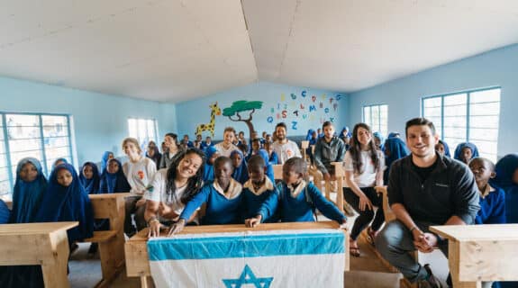 Members of the first Afrikan delegation sit with students in a renovated classroom in a school in Malindi, Tanzania, in May 2021.(Idan Arad/Courtesy of Afrikan)